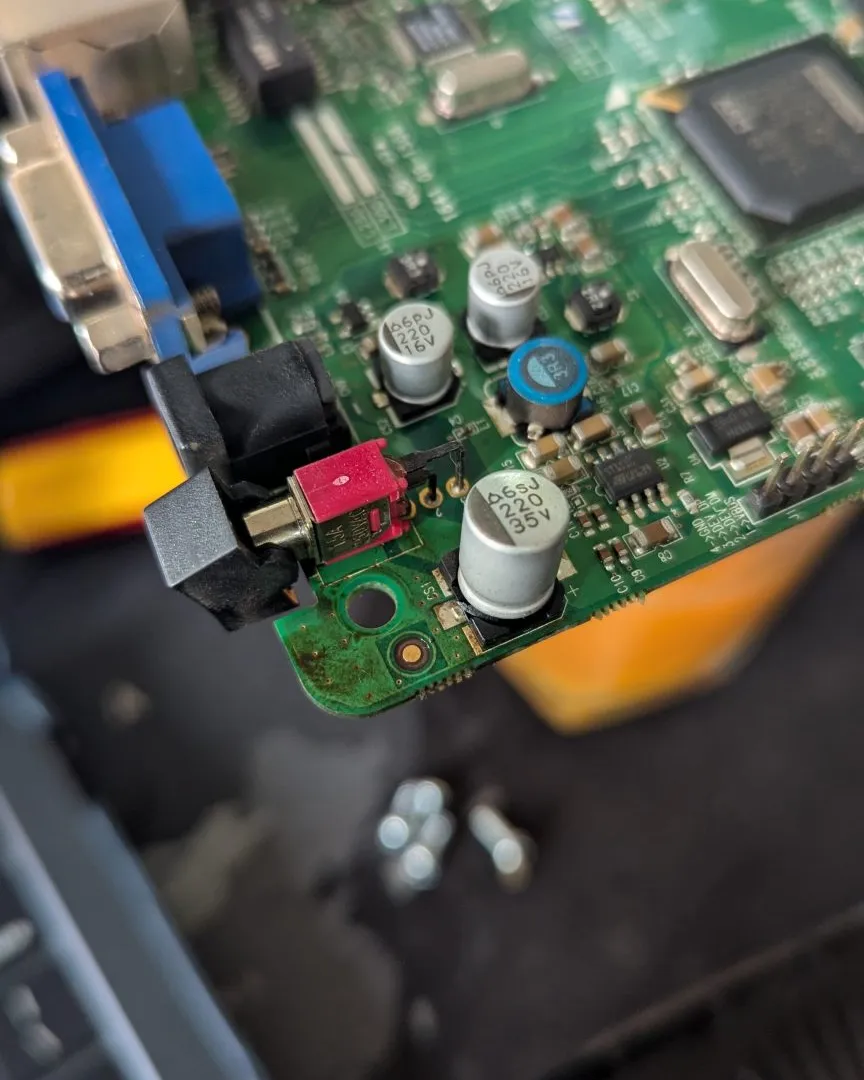 A close view of a green circuit board shows capacitors, connectors and other components.